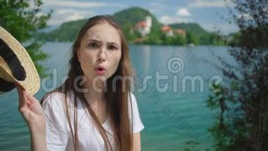女人正在改变脸上的表情，在雪橇湖和岛上的岸边做鬼脸
